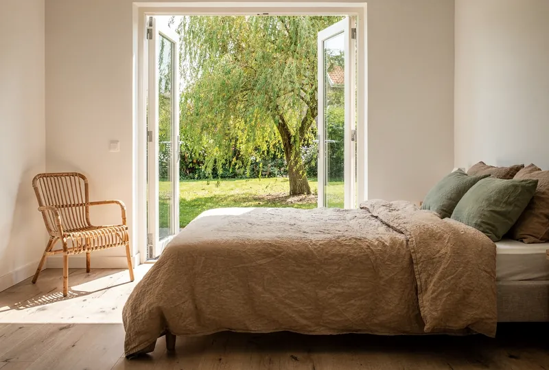 Tuinkamer met openslaande deuren naar de wilg